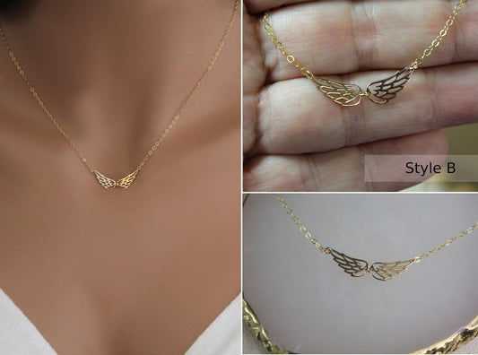 Double Angel Wing Necklace in Gold filled finish is displayed on a manneuin torso, in a woman's hand, and laying on a marble surface.