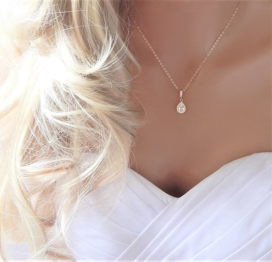 Mannequin wearing a gold teardrop pear diamond cz necklace with a bridal dress and loose curly hair..