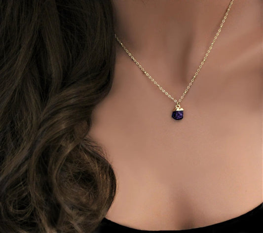 Mannequin torso with curly brunette hair is wearing a gold filled necklace with a satellite chain featuring a small electroplated natural amethyst gemstone pendant for a february birthstone alternative.