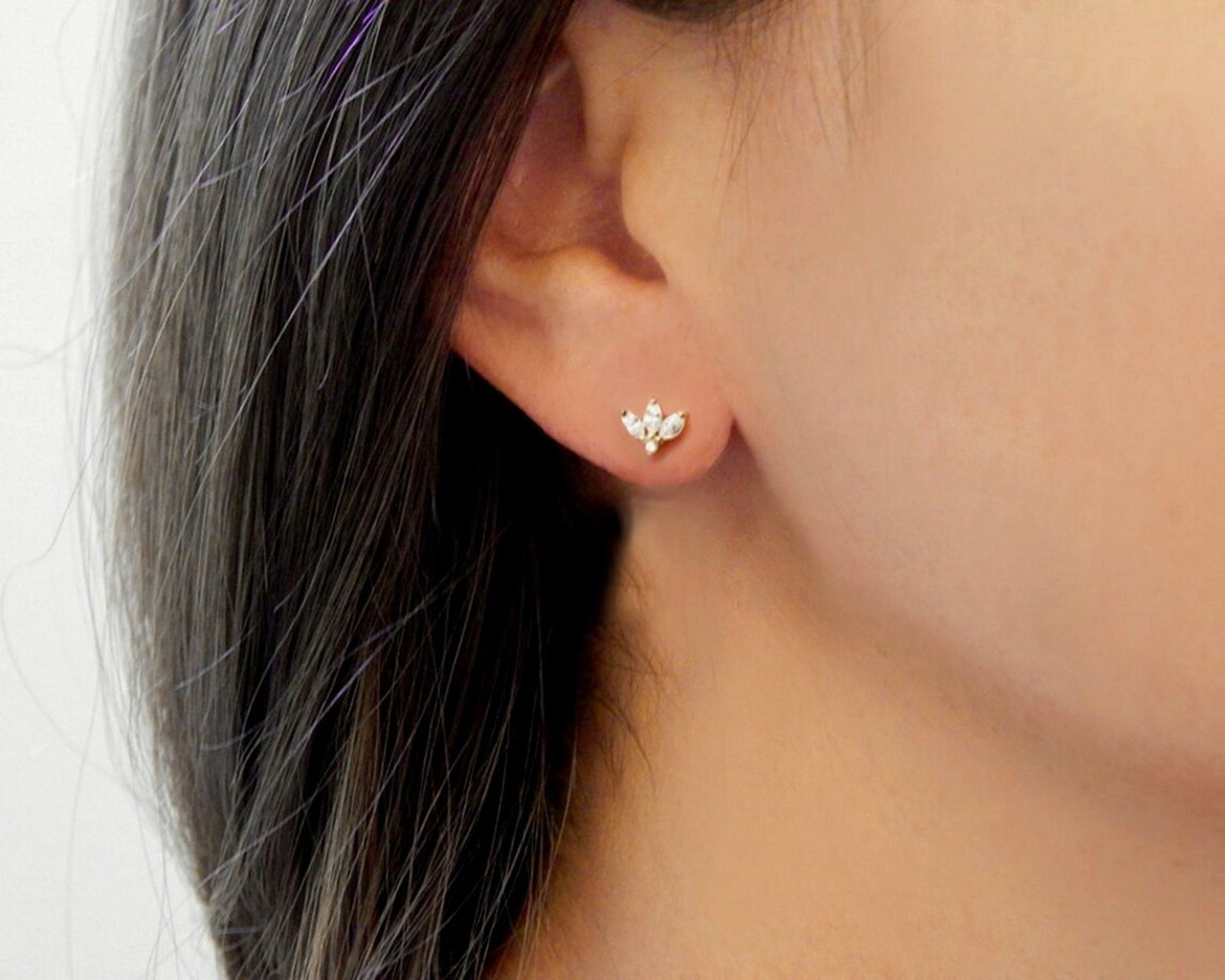 Woman's ear and profile wearing a simple diamond cz gold earring stud for sensitive skin.
