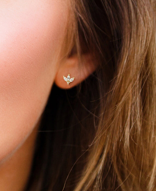 3 marquise shaped diamond earring posts on a brunette model's ear.