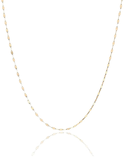 Solid gold necklace chain with sequin links hanging against a blank white background with a reflective surface underneath.