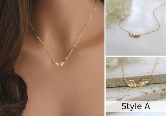 Double Angel Wing Necklace in Gold filled finish is displayed on a manneuin torso, laying on a marble surface, and resting against natural stone tiles..
