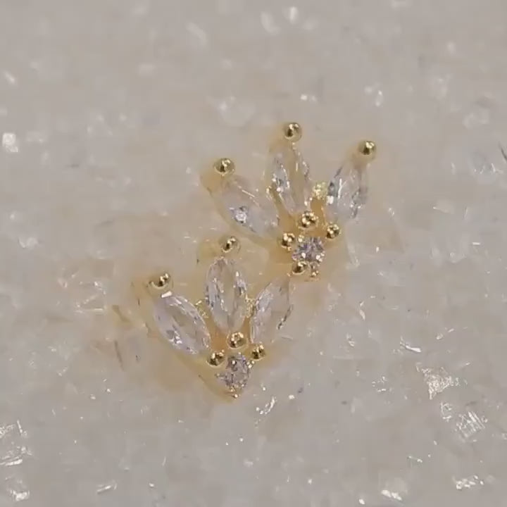 Diamond stud earrings reflecting the light off their marquise cut faces as they slowly rotate.