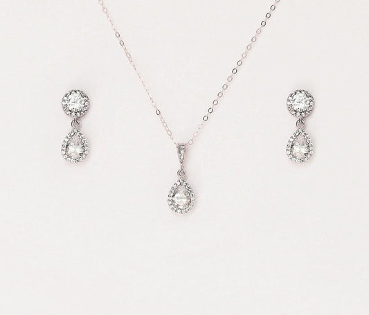 Matching silver necklace and earring set with paved teardrop cubic zirconia on a blank background.