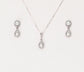 Matching silver necklace and earring set with paved teardrop cubic zirconia on a blank background.