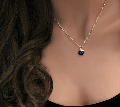 Mannequin torso with curly brunette hair is wearing a gold filled necklace with a satellite chain featuring a small electroplated natural amethyst gemstone pendant for a february birthstone alternative.