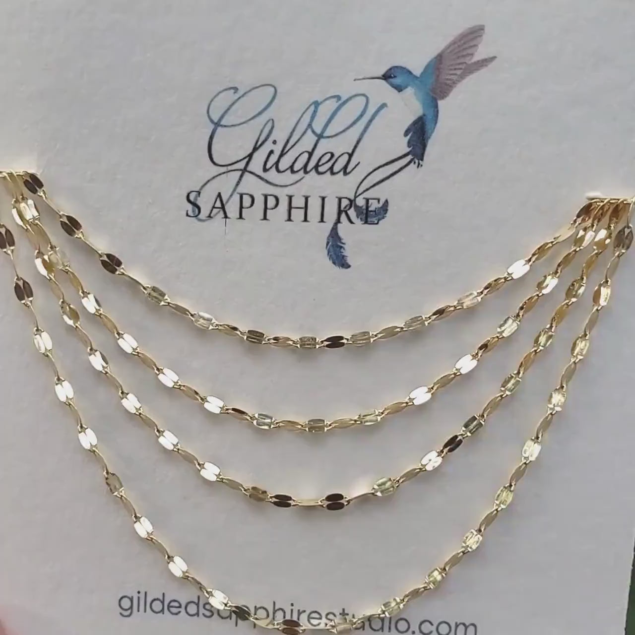 Sequin necklace chain on a necklace card that glimmers and reflects the sunlight.