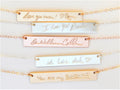Gold filled, sterling silver, and rose gold filled jewelry engraving bar with custom handwriting messages engraved on each surface, attached to necklace chains against a plain white background.
